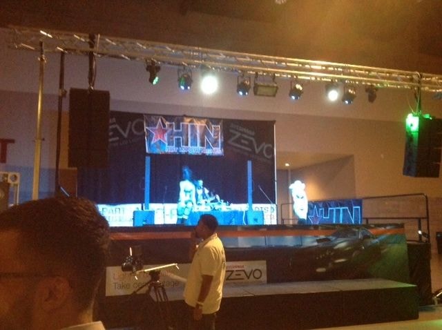 Indoor event venue with stage and blue neon lighting