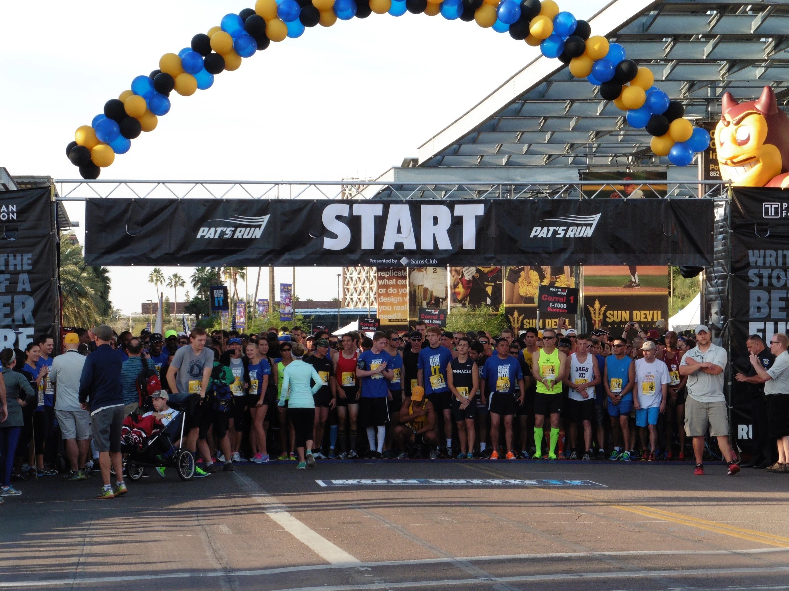 Outdoor running event start line with crowd and balloons